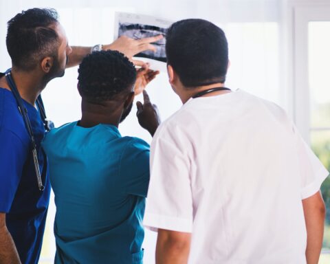 three person looking at x ray result