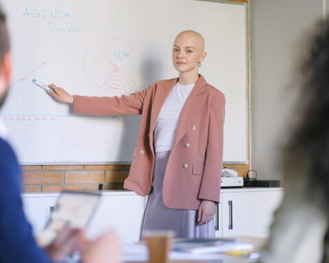 bald woman near whiteboard with charts