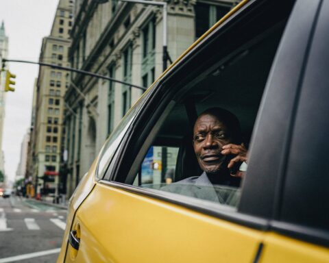 man sitting by the window of a yellow car