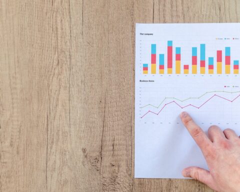 person pointing paper line graph