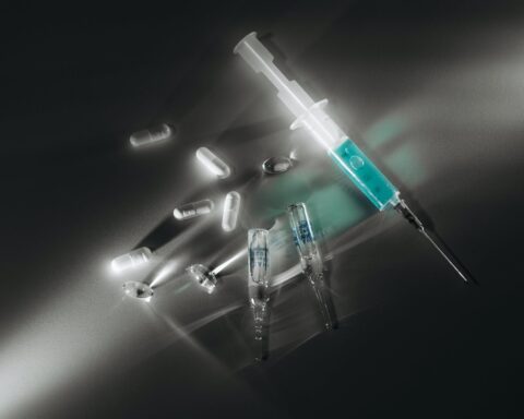 syringe and capsules on white surface