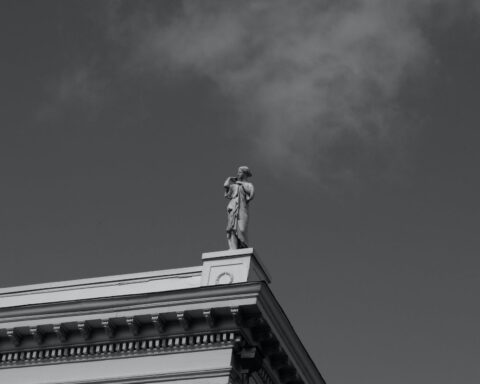 grayscale photo of a statue on top of a building