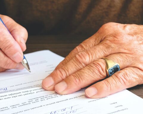 person signing document paper