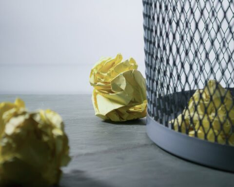 focus photo of yellow paper near trash can