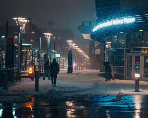 people walking on snow covered sidewalk at night