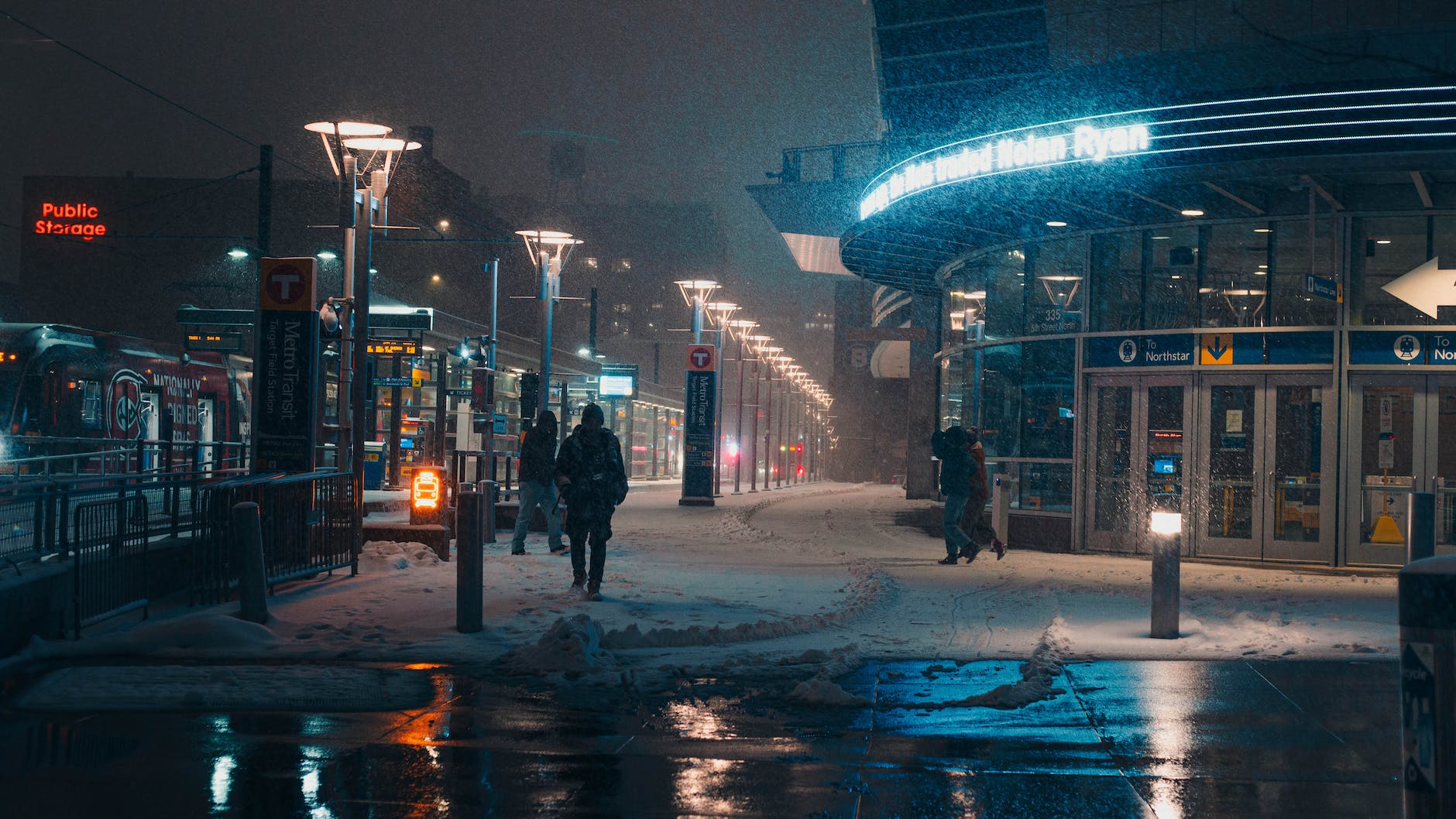 people walking on snow covered sidewalk at night