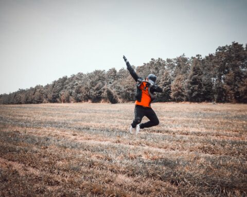 person jumping over grass