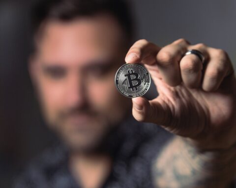 person holding silver bitcoin coin