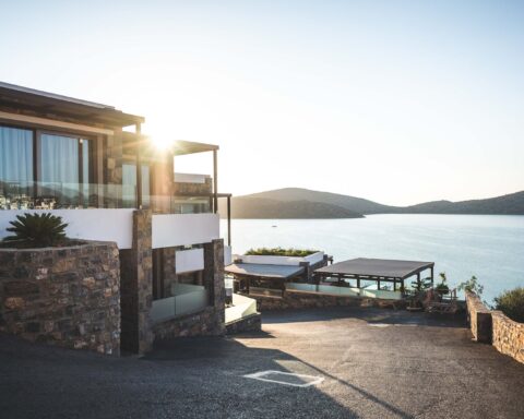 sun piercing of brown concrete house near sea