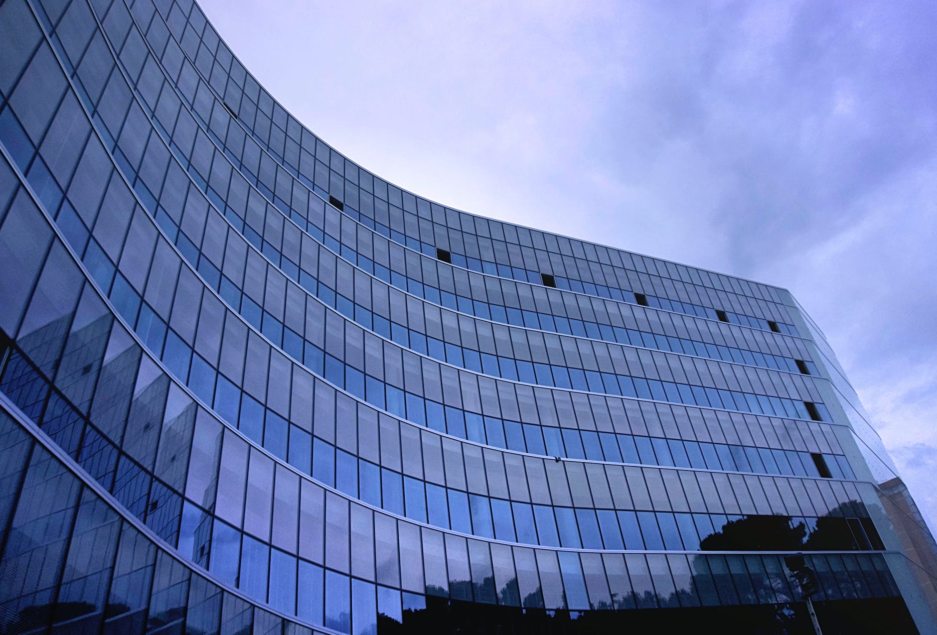 fish eye view photo of glass high story building over white cloudy sky during daytime