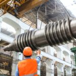 man standing beside heavy equipment