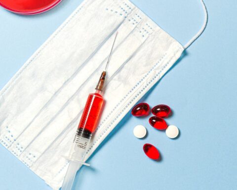 syringe and pills on blue background