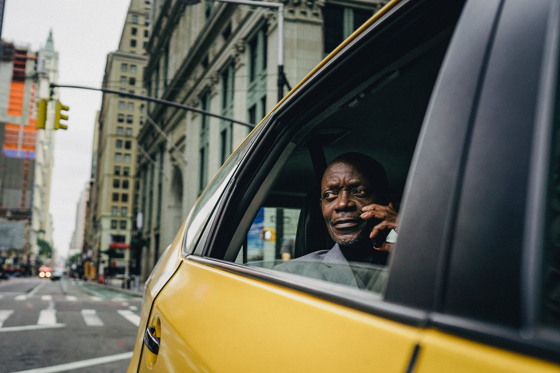 man sitting by the window of a yellow car