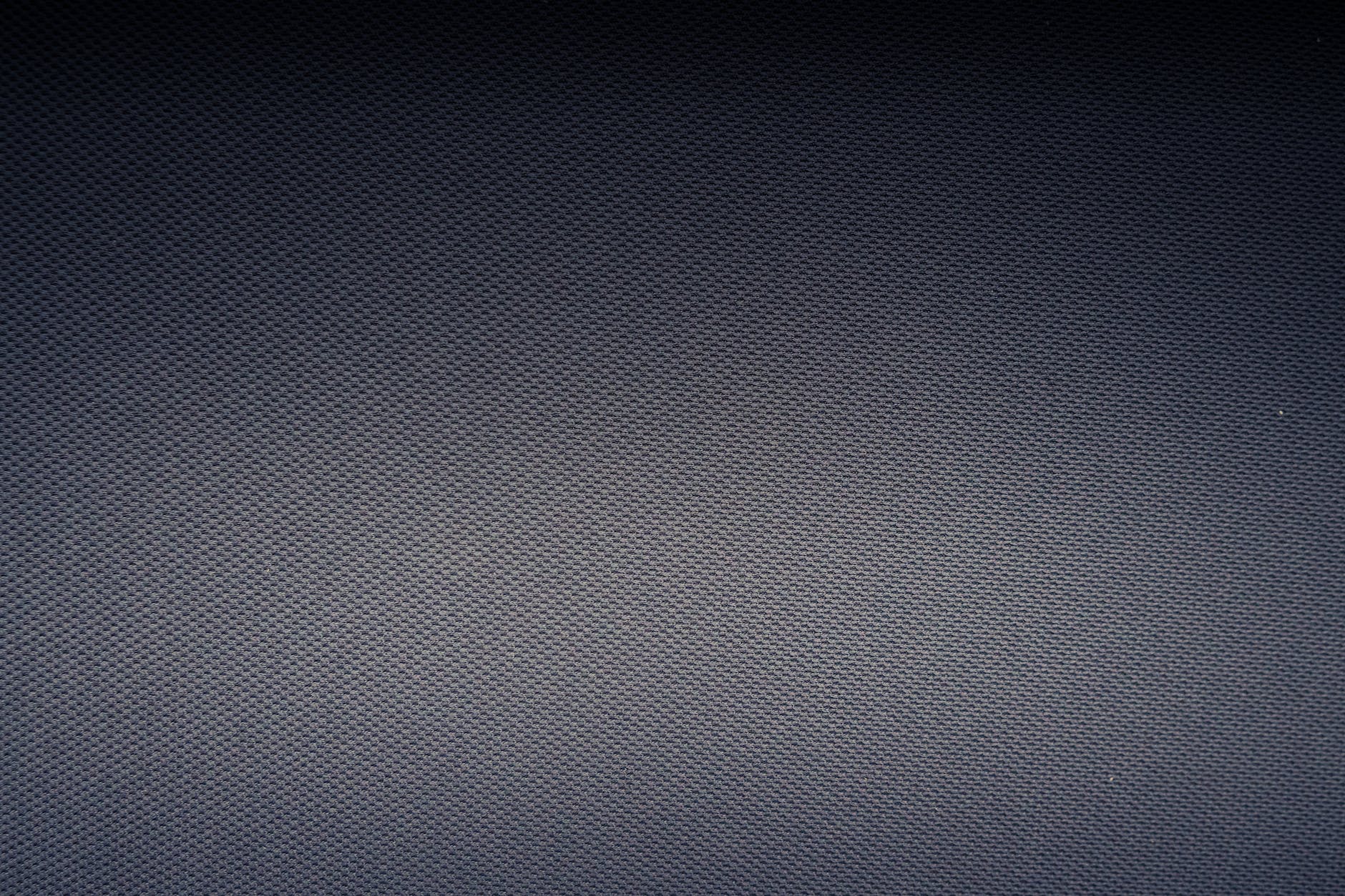 textured background of carbon fiber fabric with tiny holes