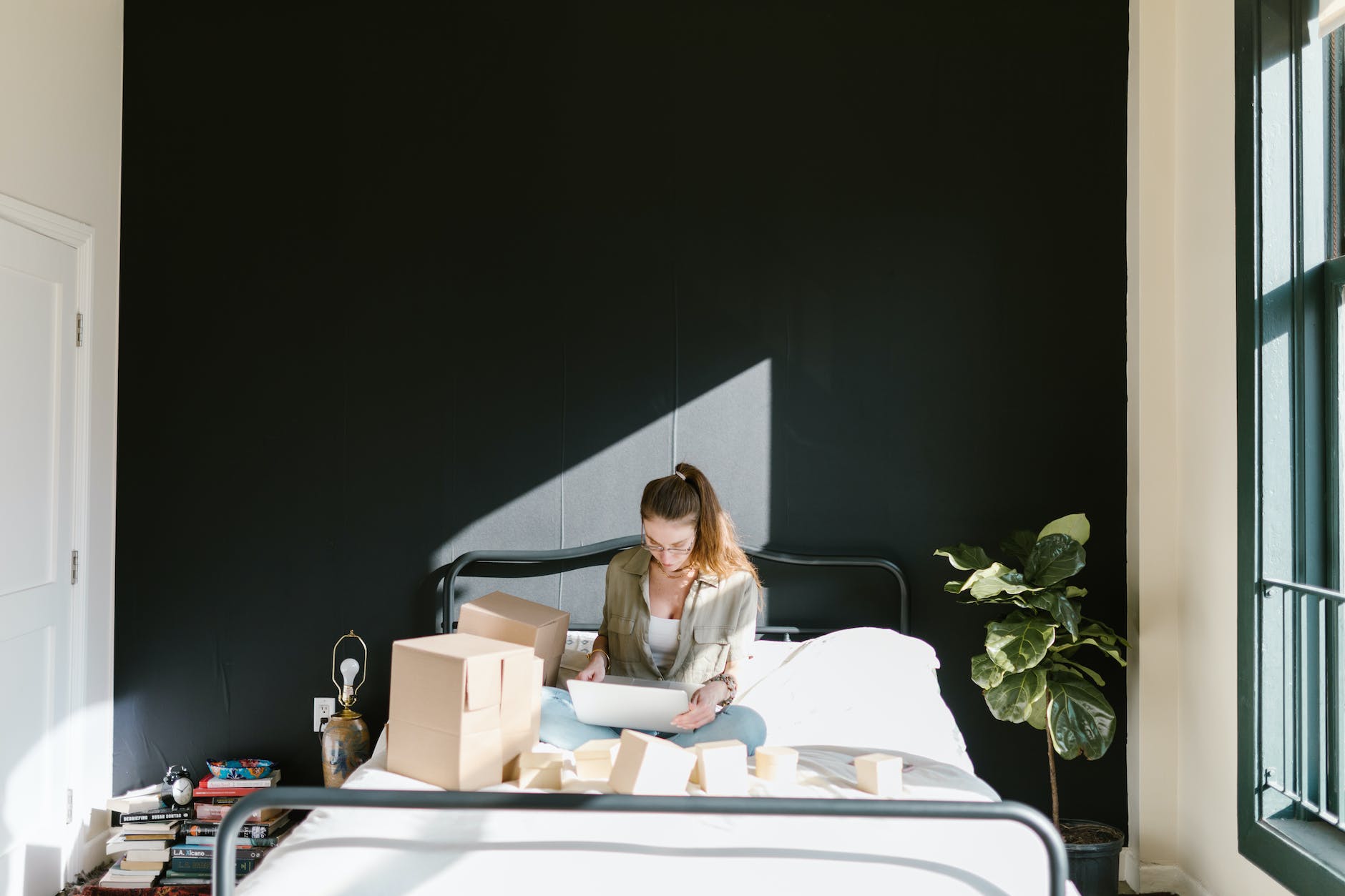 a woman using a laptop while in bed