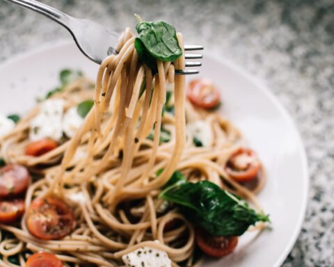 selective focus photography of pasta with tomato and basil