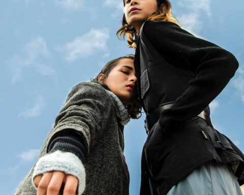 low angle photography of two women standing under white and blue sky