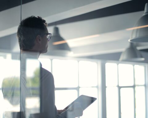 formal man with tablet giving presentation in office