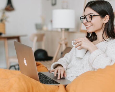 woman having coffee while using laptop