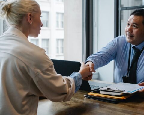 ethnic businessman shaking hand of applicant in office