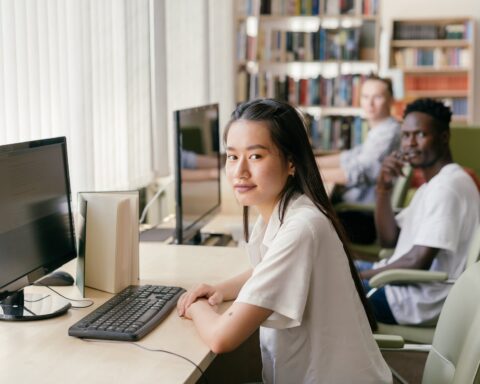 a woman sitting at the table with desktop computer